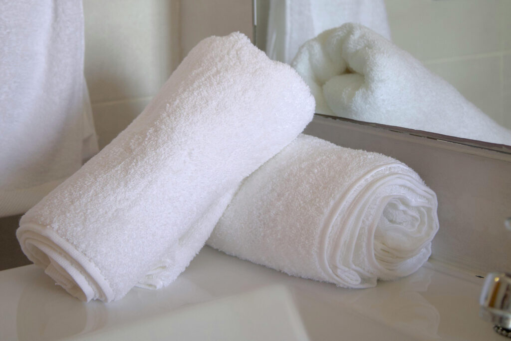 Rolled white towels prepared for short-term rental or Airbnb cleaning service