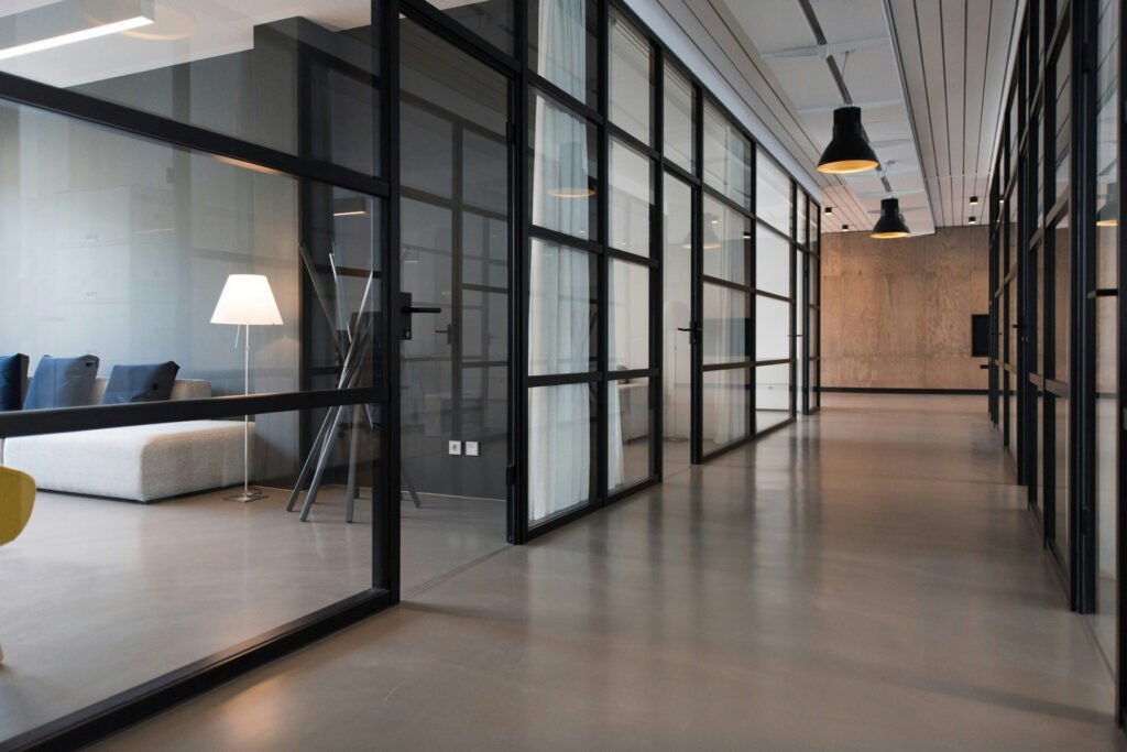 Modern office hallway with glass partitions and minimalist interior design
