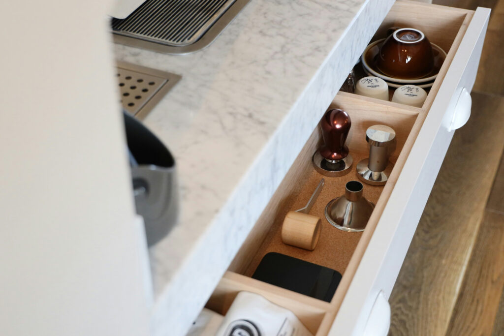 Organized kitchen drawer with neatly arranged household items and storage compartments